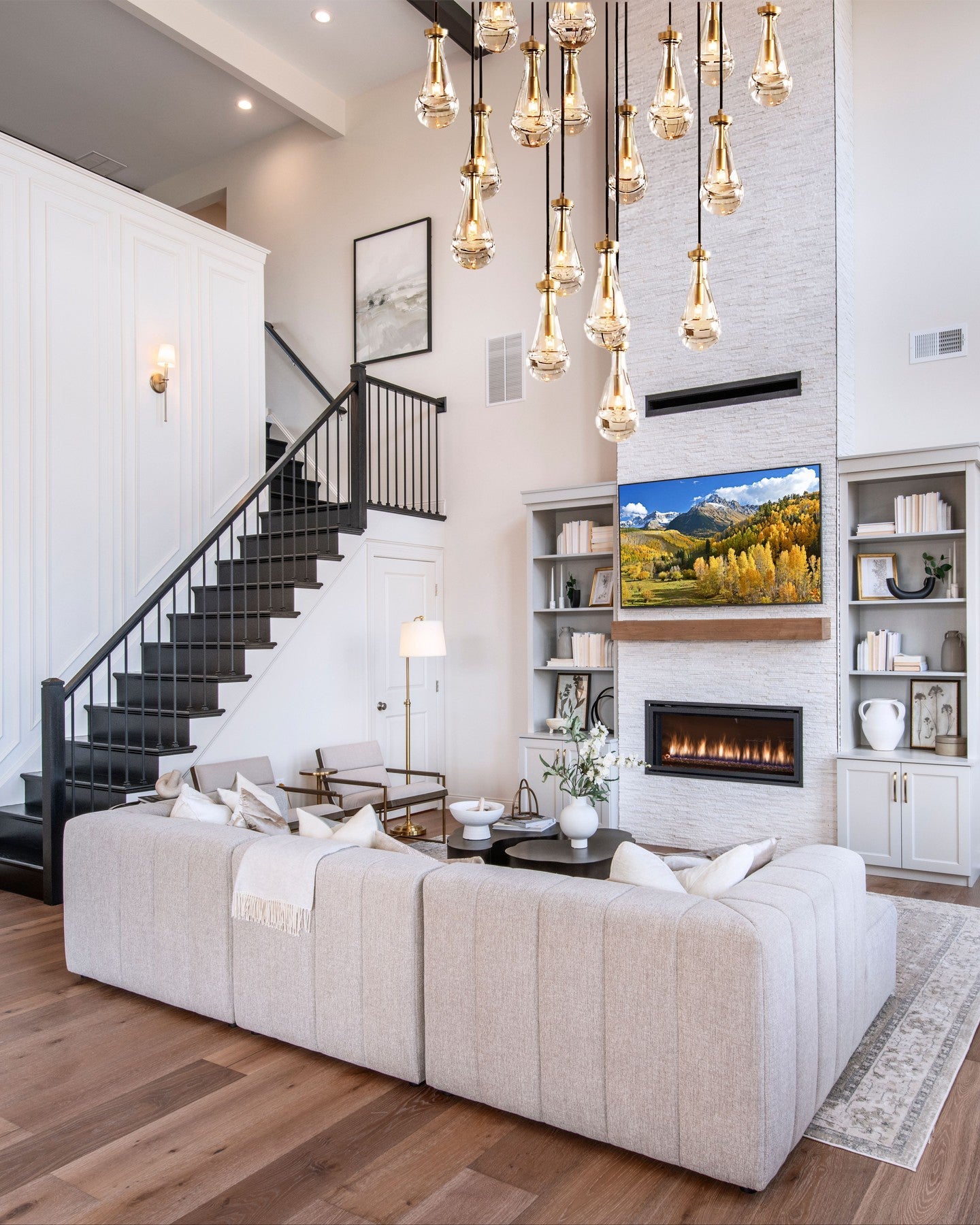 Modern living room with staircase, fireplace, and decorative elements.