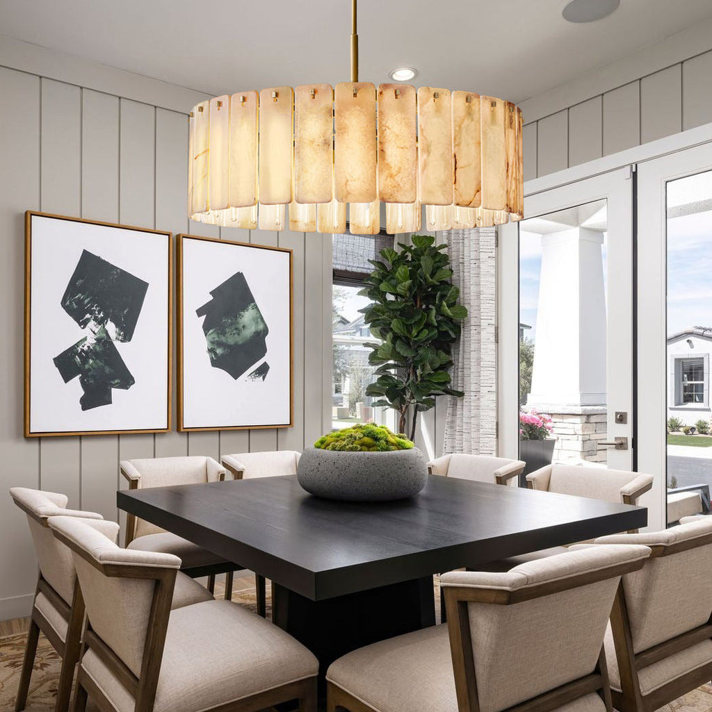 Dining room with a dark wooden table, beige chairs, and a large light fixture.